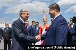 Президент Казахстана Касым-Жомарт Токаев (слева) приветствует прибывшего с визитом председателя КНР Си Цзиньпина в аэропорту. Астана, 16 июня 2025 года