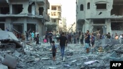 Люди шукають предмети, які можна врятувати, серед уламків будівлі, зруйнованої під час ізраїльського бомбардування в районі Шейх Радван міста Газа 11 серпня 2024 року