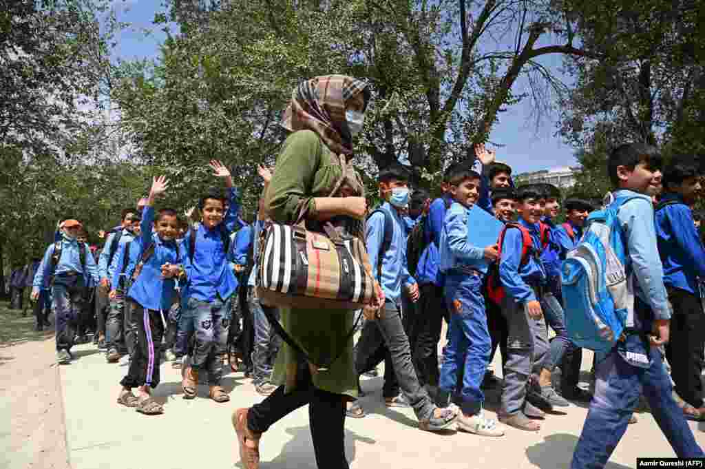 Despite the risks, some schools have reopened. These students and their teacher at a Kabul middle school were photographed on their way to class on August 30.  