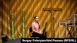 Дочь руководителя религиозной общины позирует для фотографии на главной сцене в церкви