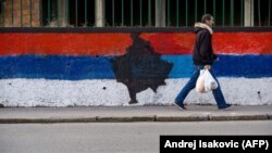 Пішохід біля стіни, розфарбованої в кольори сербського національного прапора з картою Косово посередині, Белград, 12 лютого 2018 року