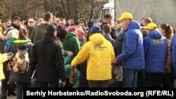 Молодые люди в курточках с фамилией кандидата в президенты раздают детям пакеты с конфетами