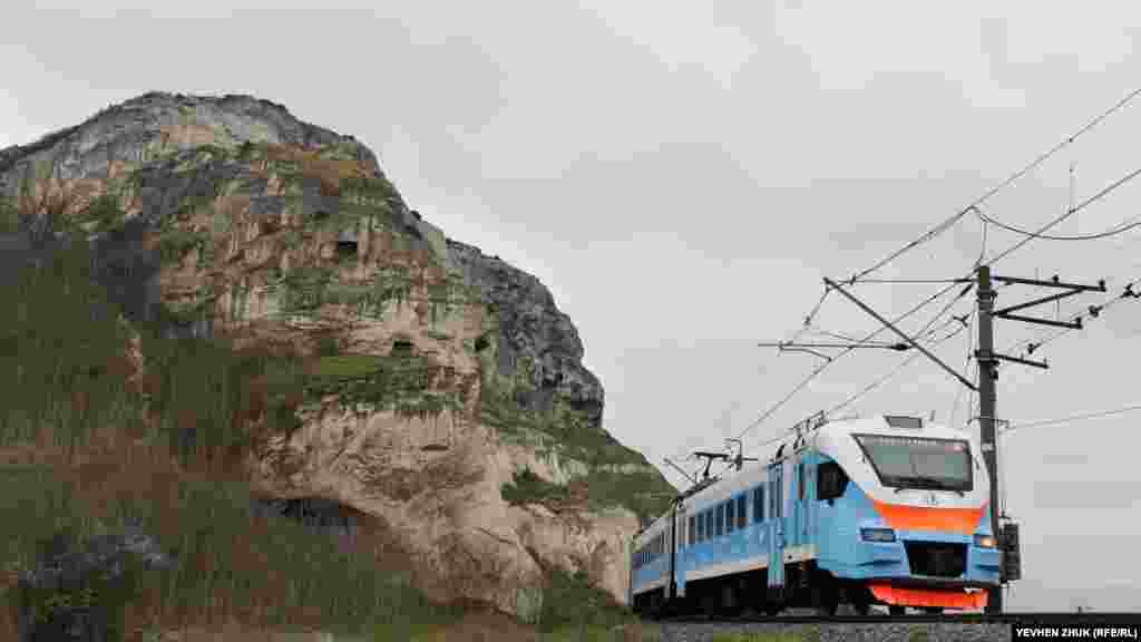 Электропоезд проходит рядом со скалой и монастырем в Инкермане. Корреспондент Крым.Реалии посмотрел, как выглядит сейчас Загайтанская скала и ее окрестности
