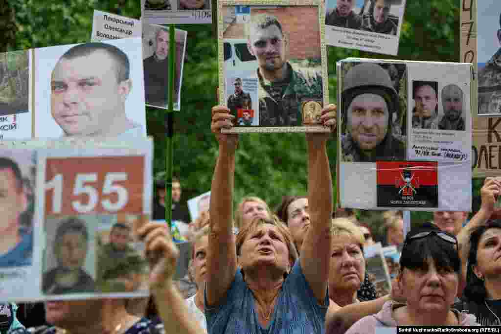 Родичі зниклих безвісти українських військових зустрічають звільнених з полону бійців та показують портрети з надією дізнатися хоч якусь інформацію про долю своїх близьких