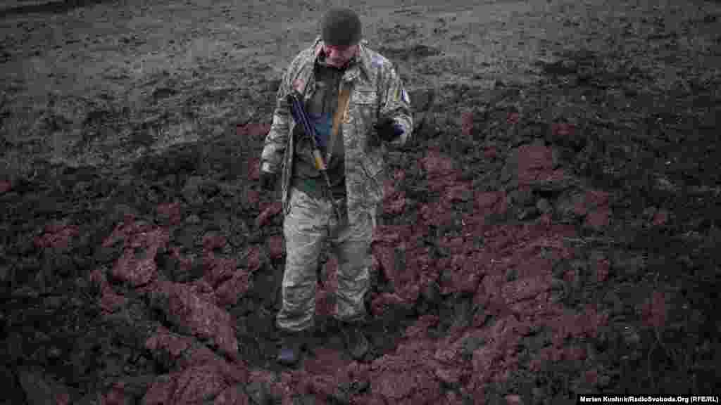 Українській військовий прочитав нам коротку лекцію про те, що залишається навколо після «прильоту» 152 мм сняряду від САУ. Яма на фото – це наслідок нічного обстрілу перед нашим приїздом.  На фото - Дмитро Годзенко (позивний – «Годзилла»), який загинув 31 березня під час мінометного обстрілу. До демобілізації йому залишалося лише 3 дні. Фотогалерея: Кияни попрощалися з Дмитром Годзенком, який загинув на Донбасі