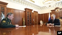 Președintele rus și șeful Statului Major rus, Valeri Gherasimov, la întâlnirea de sâmbătă, după care liderul de la Kremlin a anunțat încetarea atacurilor, de Paști.