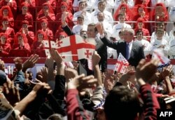 Президент Грузії Саакашвілі (ліворуч) і президент США Джордж Буш (ліворуч) махають натовпу. Тбілісі, 10 травня 2005 року