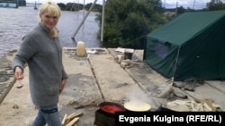 Ольга Сысоева (Воронина) готовит обед на крыше гаража, пристроенного к сельской библиотеке. Еврейская АО, с. Нижнеленинское