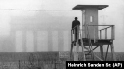 Когда стена была совсем юной. Житель Западного Берлина смотрит с наблюдательной вышки на восточную часть города у Бранднебургских ворот. Ноябрь 1961 года