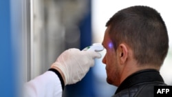 Medicinski tehničar meri temperaturu osobe, Srbija