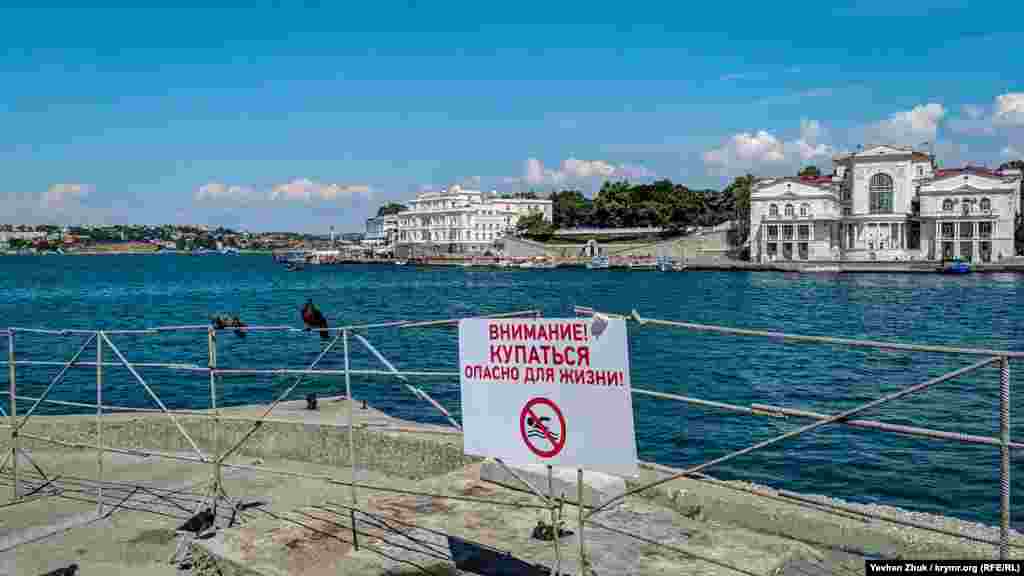 Рятувальна станція розташована на початку пляжу, де з'єднуються Севастопольська і Артилерійська бухти – тут купатися заборонено. На протилежному боці – будівля Інституту біології південних морів (зліва) і Палац дитинства і юності (праворуч)