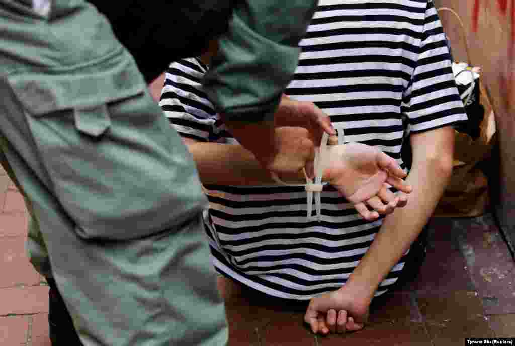 Поліція зв’язує руки протестувальника кабельною стяжкою під час ходи проти нового закону про нацбезпеку в Гонконгу 1 липня