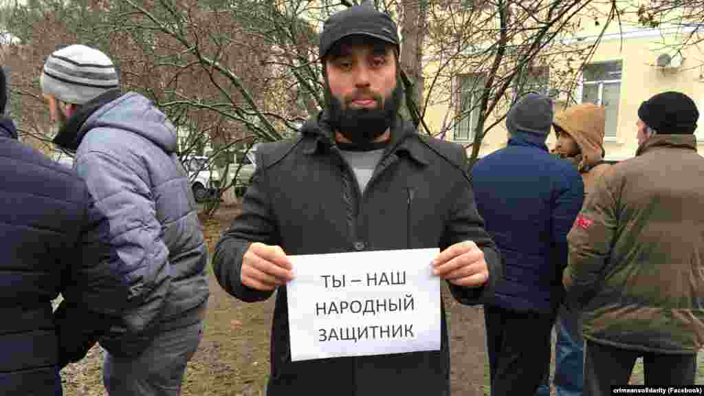 Люди, пришедшие поддержать адвоката, фотографируются с плакатом «Ты – наш народный защитник»