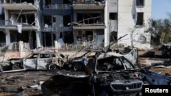 Згорілі автомобілі та пошкоджена будівля на місці падіння ракетного удару Ірану по Ізраїлю в Беер-Шеві, Ізраїль, 20 червня 2025 року.