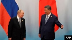 ჩინეთის ლიდერი სი ძინპინი ესალმება რუსეთის პრეზიდენტ ვლადიმირ პუტინს შანხაის თანამშრომლობის ორგანიზაციის (SCO) ფოტოსესიის შემდეგ