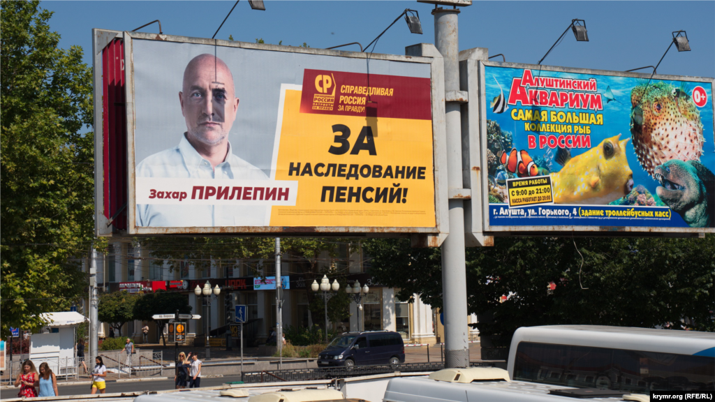 Российский писатель и журналист Захар Прилепин от «Справедливой России» возвышается с тыльной стороны академического музыкального театра, на проспекте Кирова. С октября 2016 года по июль 2018 года был заместителем командира батальона спецназа по работе с личным составом боевиков «ДНР». Конечной целью войны Прилепин называл «победу Донбасса через возвращение Малороссии и русского города Киева». СБУ открыла уголовное производство по ч. 1 ст. 258-3 (участие в деятельности террористической организации) и ч. 1 ст. 258-5 (финансирование терроризма) Уголовного кодекса Украины