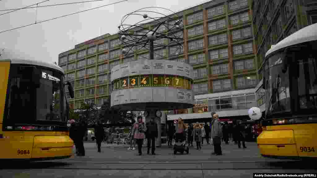 Іще одне з визначних місць Східного Берліну – світовий годинник на Александерплац, який показує час у містах по всьому світі. 4 листопада 1989 року тут відбувся наймасовіший мітинг в історії НДР – за різними оцінками, в ньому взяли участь від 200 тисяч до мільйона людей. Листопадові мирні виступи під гаслами «Ми – народ!» закінчилися падінням Берлінського муру, який десятки років розділяв столицю Німеччини. Також – трамваї. Якщо ви їх бачите – ви у Східному Берліні