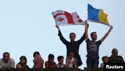 Люди тримають грузинський і український прапори в Тбілісі, 27 червня 2014 року