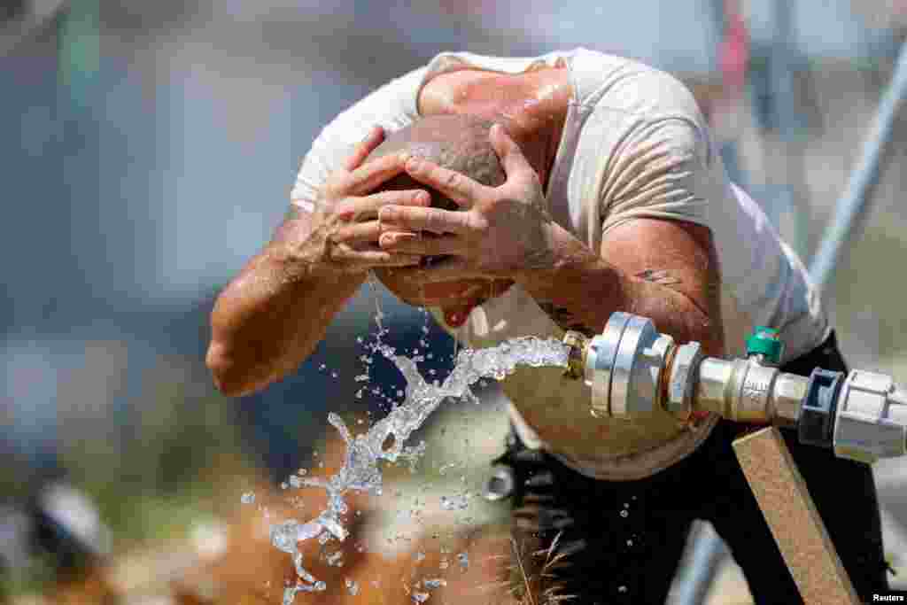 Строитель освежается водой на строительной площадке в Мюнхене, Германия, 1 июля 2025 года. REUTERS/Michaela Stache