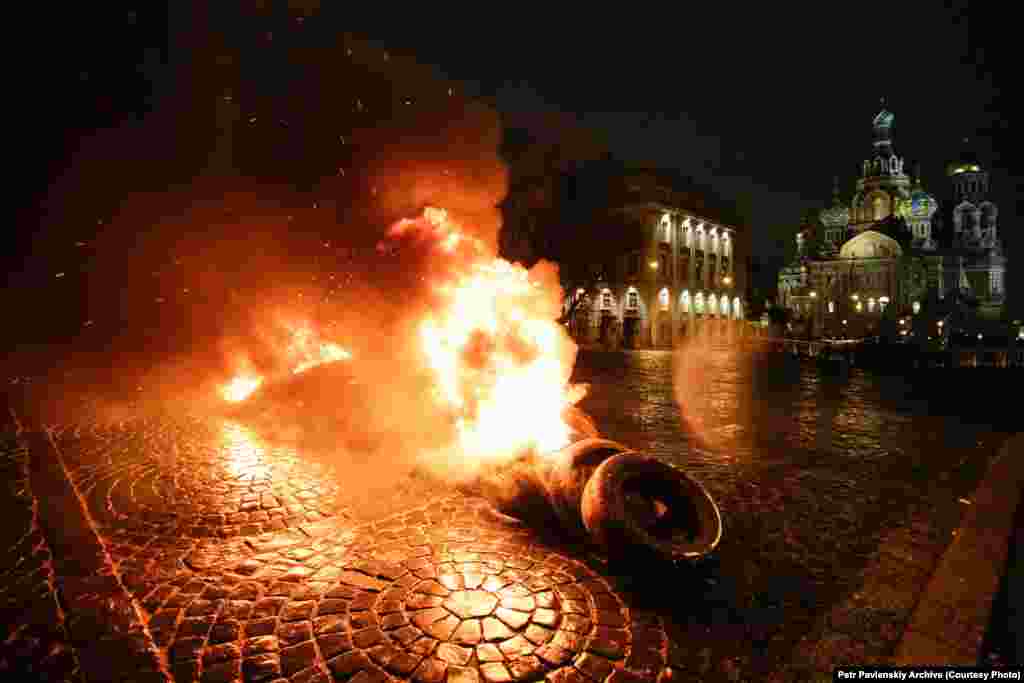 Акция "Свобода" у храма Спаса-на-Крови в Петербурге – в поддержку Евромайдана. 23 февраля 2014 года: "Горящие покрышки, флаги Украины, черные флаги и грохот ударов по железу - это песня освобождения и революции, Майдан... проникает в сердце Империи... В день, когда государство призывает праздновать день защитника отечества, мы призываем всех встать на... защиту своей свободы. Мосты горят, и назад дороги уже нет".