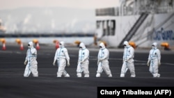 Люди у захисних костюмах біля лайнера Diamond Princess в порту Йокогама, 10 лютого 2020 року