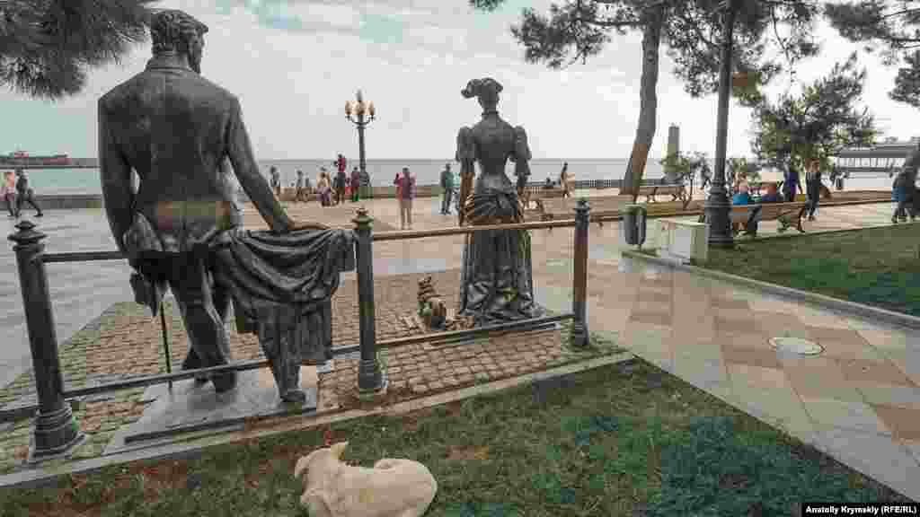 Дворняга за бронзовой скульптурной композицией «Дама с собачкой»