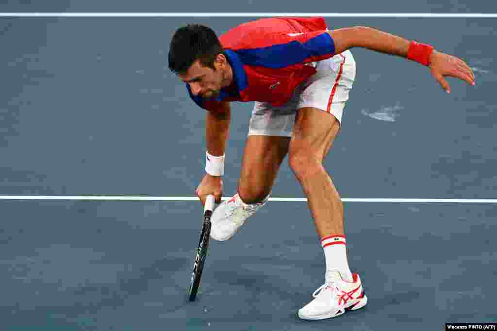 Новак Джокович відбиває м'яч представника Німеччини Олександра Звєрєва під час їхнього півфінального тенісного поєдинку у чоловічому одиночному розряді.Токіо, 30 липня 2021 року