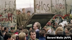 Утро 11 ноября 1989 года. Жители Западного Берлина собрались у стены, чтоб посмотреть, как пограничники ГДР начинают ее сносить.