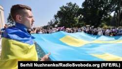 Акция под Верховной Радой Украины. Люди написали пожелания на большом крымскотатарском флаге, который запустят в Крым. Киев, 15 июня 2021 года