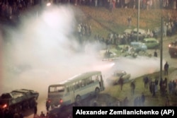 Радянські танки, у хмарі сльозогінного газу, прокочуються через барикаду із автомобілів перед вільнюськім телецентром. Литва, 13 січня 1991 року