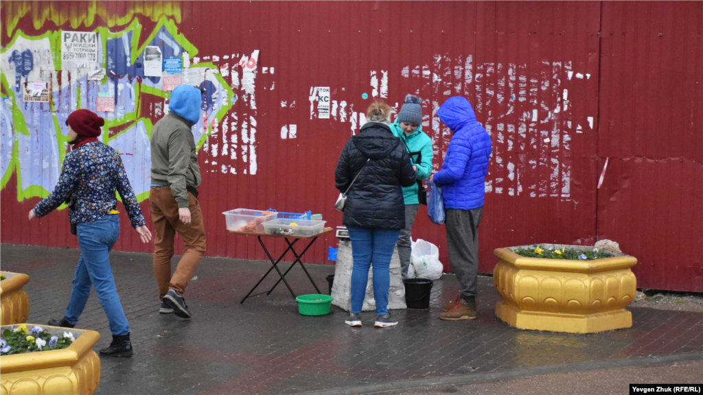 Возле развалин кинотеатра «Родина» девушка продает креветки и мидии