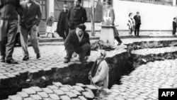 Fotografija snimljena u travnju 1960. u Valdiviji, na kojoj ljudi gledaju ogromnu pukotinu na ulici nastalu zbog potresa magnitude 9,5 koji je pogodio to područje, 22. svibnja 1960.