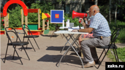 В Пушкине устроили голосование на лавочке во дворе дома. Мобильный УИК перемещается вдоль дома в течение дня. Людей зазывают проголосовать через мегафон
