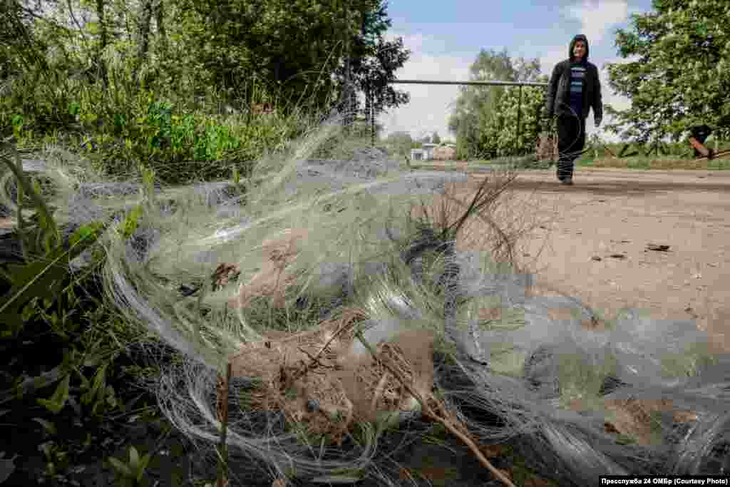 Однією із загроз у місті є дрони, на фото – чоловік проходить повз оптоволоконний кабель, який залишився від FPV-дронів, що масово атакують місто
