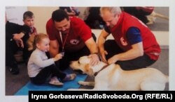 Фото со стенда в Федерации кинологического спорта в Мариуполе. На фото Константин Бинковский, Алексей Биринцев и Крас работают с детьми