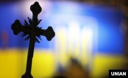 Хрест на тлі прапора України біля собору Святої Софії в Києві, де проходив Об’єднавчий собор, на якому створили Православну церкву України. Київ, 15 грудня 2018 року