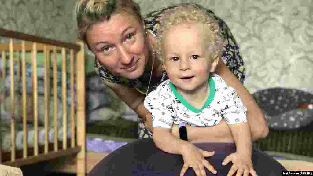 Богдан и его мама Елена Алексеева. Семья Алексеевых стала самой молодой из шести йошкаролинских семей, имеющих детей со спинально-мышечной атрофией (СМА).  Большую часть жизни ребенка его родители ведут сбор денег для того, чтобы приобрести самое дорогое лекарство в мире, которое способно вылечить заболевание. Времени на применение этого лекарства остается не очень много — оно эффективно у пациентов младше двух лет. В июле, когда был сделан этот снимок, Богдану был один год и три месяца. 