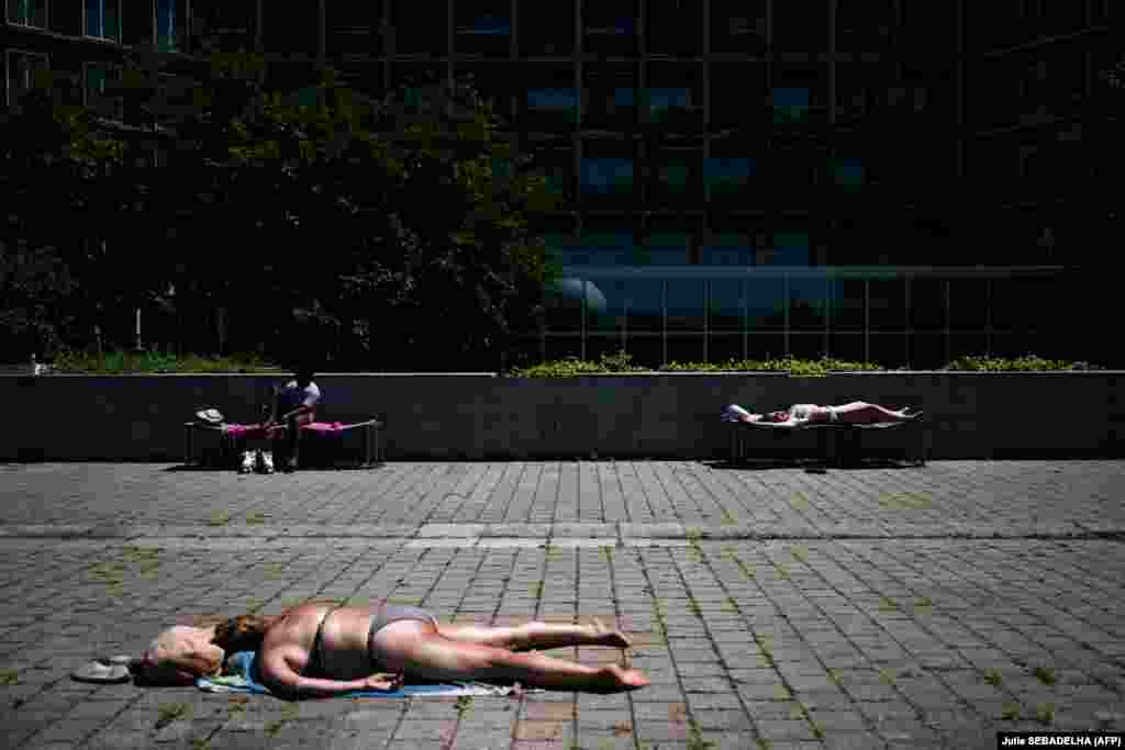 Ljudi se sunčaju u parku Andre-Citroen u Parizu, 29. juna.