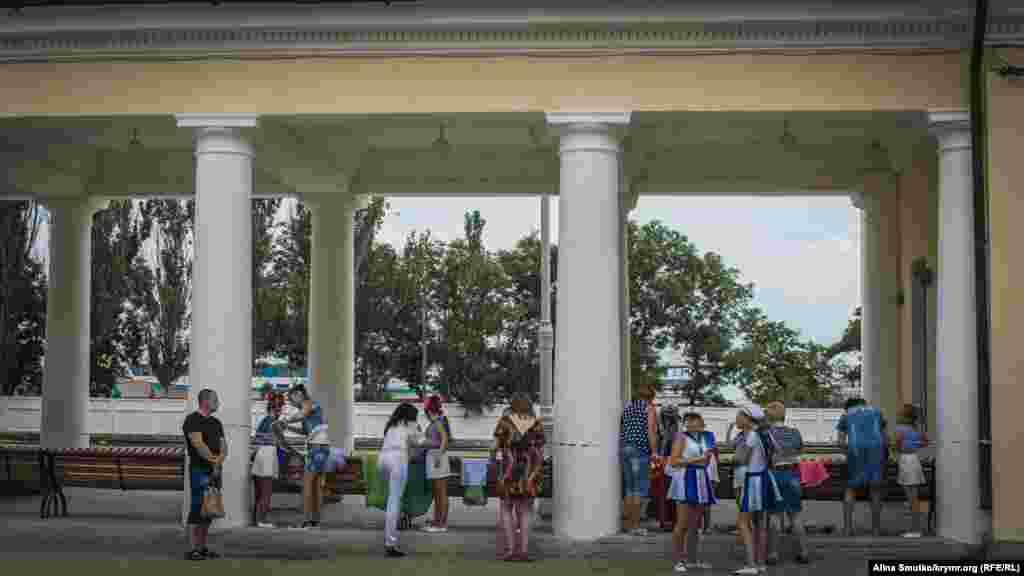 Зрители смотрят концерт возле вокзала 