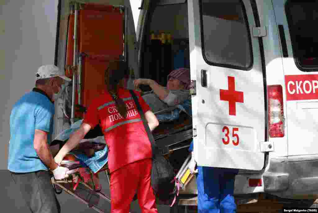 Помимо дождливой погоды, в конце июня в Крыму повсеместно начали фиксировать негативные тенденции в связи с распространением коронавирусной инфекции. 30 июня министр здравоохранения российского правительства Крыма Александр Остапенко сообщил, что количество тяжелобольных пациентов с коронавирусной инфекцией и внебольничной пневмонией увеличилось на 60%. На фото: фельдшеры скорой помощи в костюмах индивидуальной защиты во время вызова к пациенту с подозрением на коронавирусную инфекцию, Симферополь, 23 июля