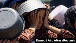 Palestinka čeka da dobije hranu iz humanitarne kuhinje u jeku krize gladi u gazi, 22. juli 2025.