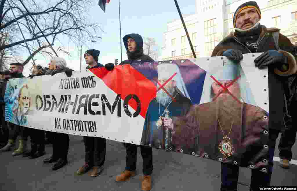 Активісти на акції біля Адміністрації президента України з банером «Агентів ФСБ обміняємо на українських патріотів!», на якому зображені, з одного боку, глава УПЦ (МП) Онуфрій і намісник Києво-Печерської лаври митрополит Павло, а з іншого боку – Микола Карпюк і Станіслав Клих, які ув’язнені в Росії. Київ, 24 листопада 2018 року