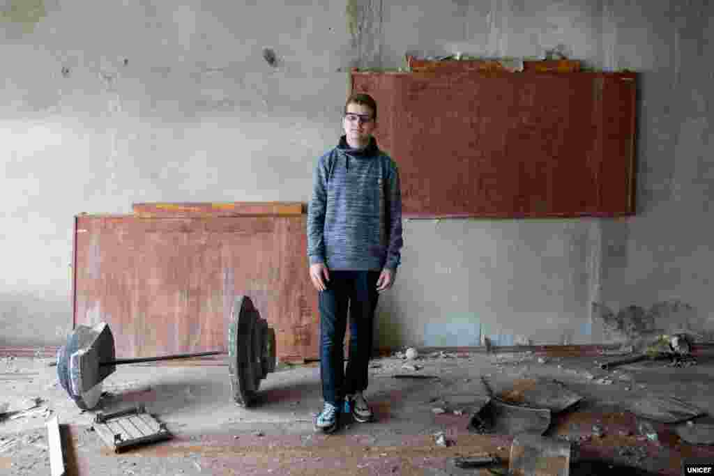 Під час найважчих боїв на початку війни усі друзі й однокласники 14-річного Олексія покинули їхнє рідне містечко Новотошківське. Воно розташоване на Донеччині за кілька кілометрів до від лінії розмежування. Там залишилося лише шість дітей його віку. «Були тільки літні люди, я і мій друг, і моя сестра. Це було дуже важко і боляче, і ми навіть молилися Богові, щоб це все закінчилося», – пригадує Олексій. Сьогодні, хоча його школа знову відкрилася, у класі Олексій ще тільки з чотирма однокласниками. Через п’ять років після початку війни усе життя в Новотошківському обертається навколо школи. У сірому цегляному будинку розташовані і середня школа, і дитячий садок. Попри те, що школа значно постраждала від обстрілів, сьогодні тут продовжують проводити заняття, спортивні заходи, вибори і семінари з питань безпеки. Школа також стає укриттям, коли починається обстріл.