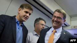 Пресс-секретарь Пентагона Питер Кук и министр обороны США Эштон Картер на борту военного самолета перед встречей с прессой