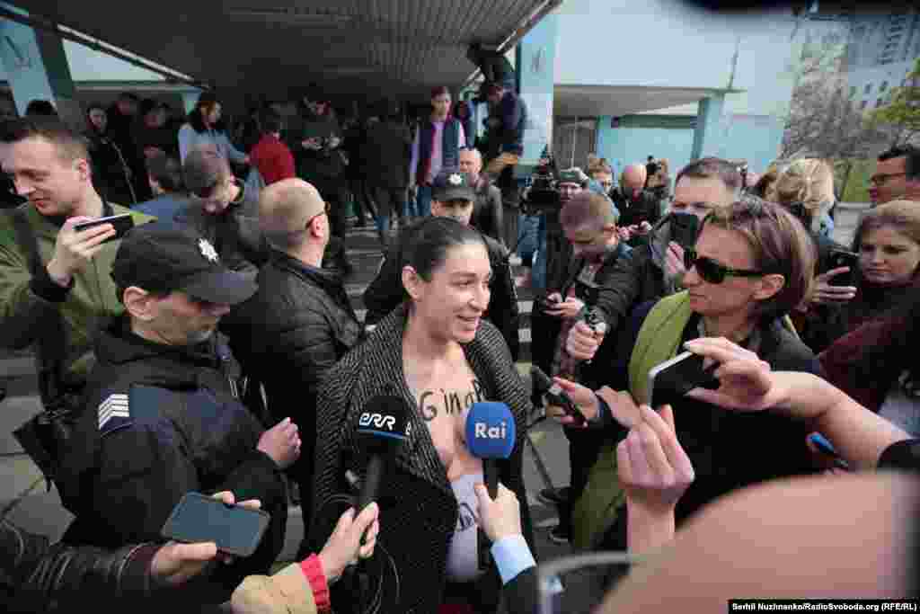 Активістка на ім’я Юлія з’явилася біля дільниці з оголеними грудьми, на яких було написано «pig in a poke» – сталий англійський вислів, аналогічний українському «кіт у мішку». «Ми не знаємо, хто прийде з Зеленським, він кіт у мішку. Ми всі це розуміємо. Це може бути смішною помилкою, смішною й фатальною. Тому зараз всі надії – в його руках практично», – сказала вона.