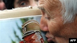 A supporter kisses a picture of Bosnian Serb military leader Ratko Mladic.