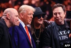 Трамп і Маск позують на фото зі своїми прихильниками. 16 листопада 2024 року