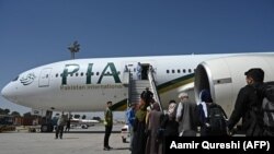 په کابل کې یوشمېر مساپر پاکستان ته د تګ لپاره د پي ای اې الوتکې ته خېژي - پخوانی انځور.