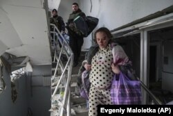 Поранена вагітна жінка спускається сходами пошкодженого від авіаудару російськими військовими пологовому будинку в Маріуполі, 9 березня 2022 року