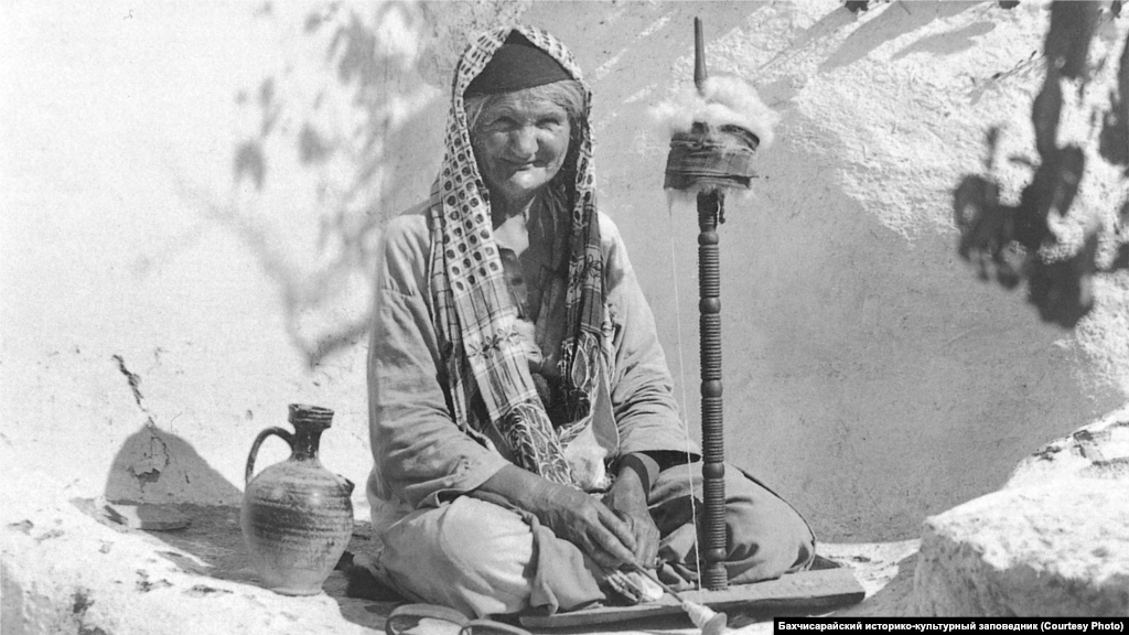 Прядильщица, 1920-ые. Самую известную крымскую легкую ткань – «атма» – делали из хлопка и льна. Работали вручную – такие прялки были в каждом крымскотатарском доме. Ткани шли на одежду, покрывала и полотенца. Если прядение было чисто женским делом, то ткачеством занимались и мужчины-ремесленники, объединенные в цех «безазы»